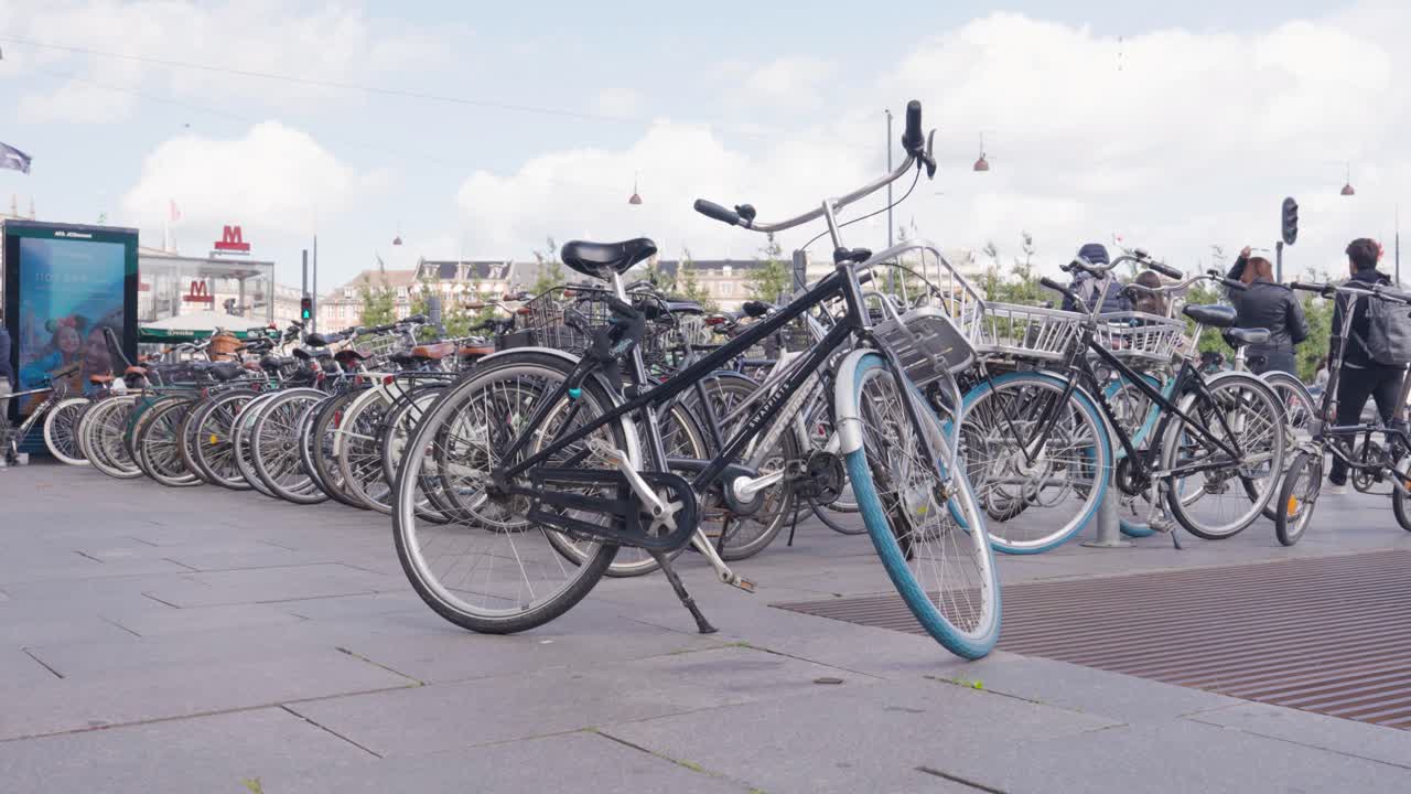 Multiple bicycles parked on sidewalk near street in Copenhagen, Denmark