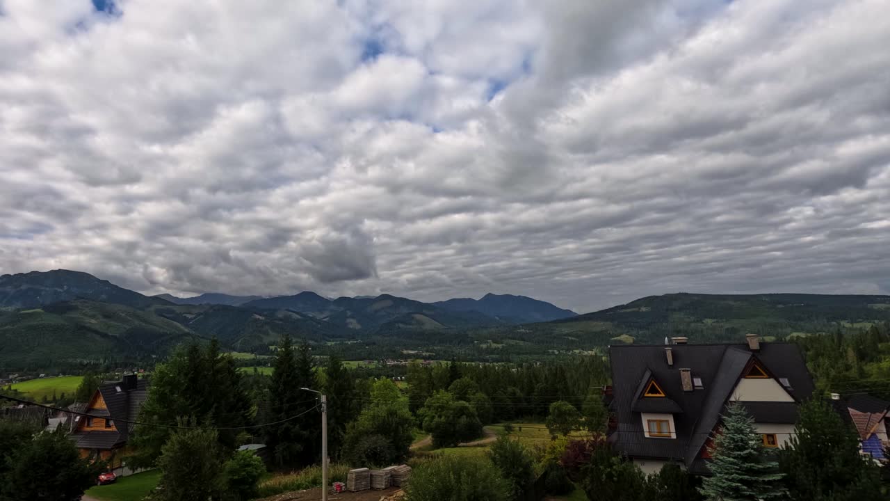 Timelapse of mountain peaks near Zakopane, Poland, during summer. Dramatic clouds drift over lush alpine landscape. Perfect for nature, travel, and cinematic outdoor visuals