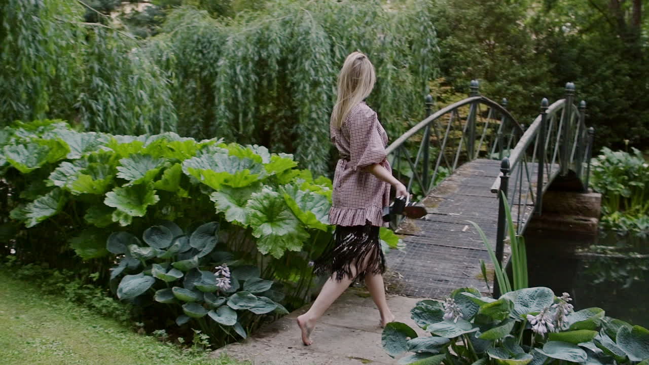 Lovely Woman Fashion Model In Barefoot Looks Back At The Camera As She Walks Through Lush Green Lawn At The Park - Slow Motion