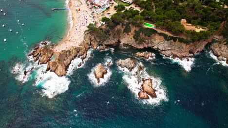 waves hit outcrops of platja mar menuda shore in tossa de mar, costa brava in girona, spain