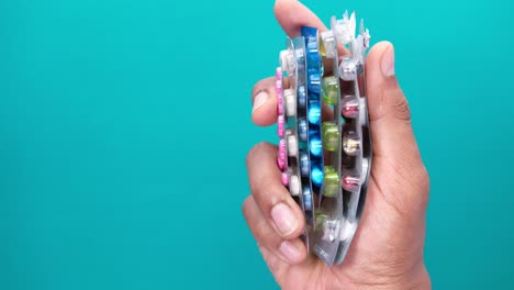 mano sosteniendo una pila de varios paquetes de medicamentos.