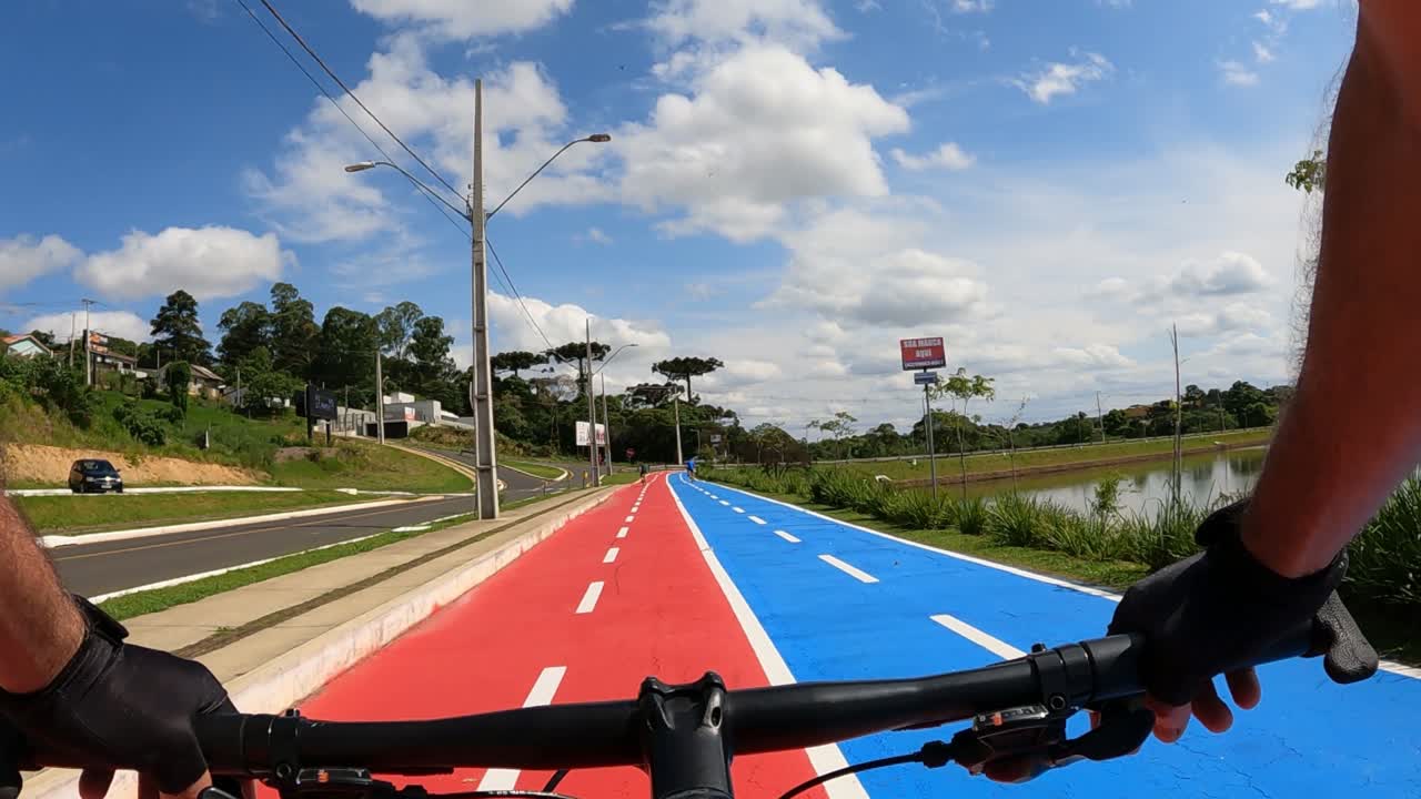 ciclista en una ciclovía compartida en un parque urbano, captura de pov