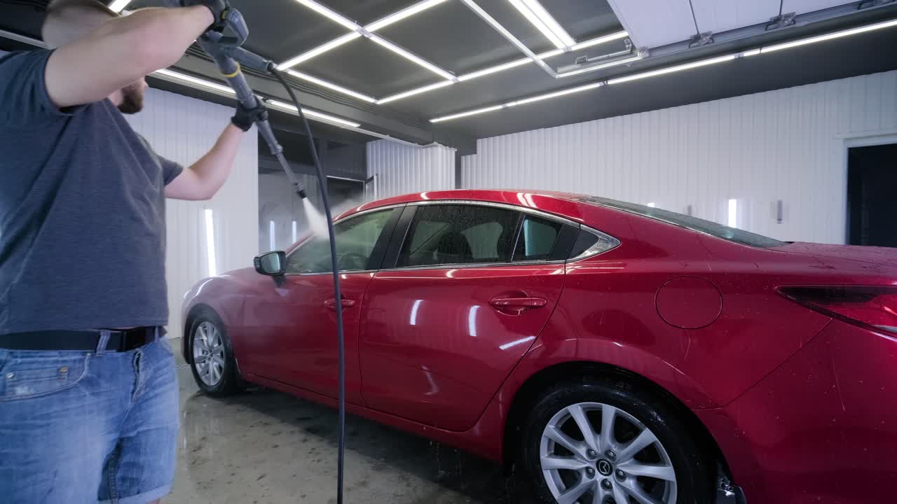 lavado de automóviles limpieza con espuma y agua a alta presión. coche rojo