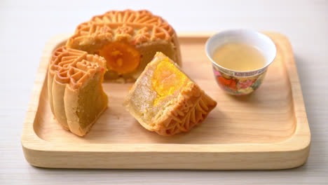 chinese moon cake durian and egg yolk flavour with tea on wood plate