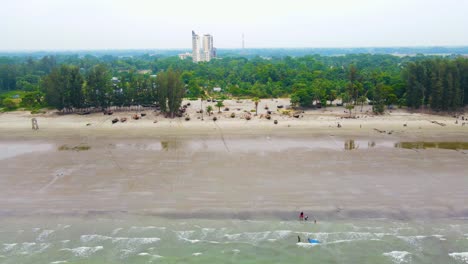 Vista-Aérea-De-La-Playa-De-Kuakata-En-Bangladesh,-Que-Muestra-A-Pescadores-Lanzando-Redes-Y-Familias-Disfrutando-De-La-Belleza-Escénica.