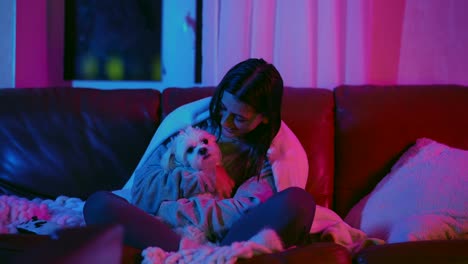 woman and dog on a couch at night