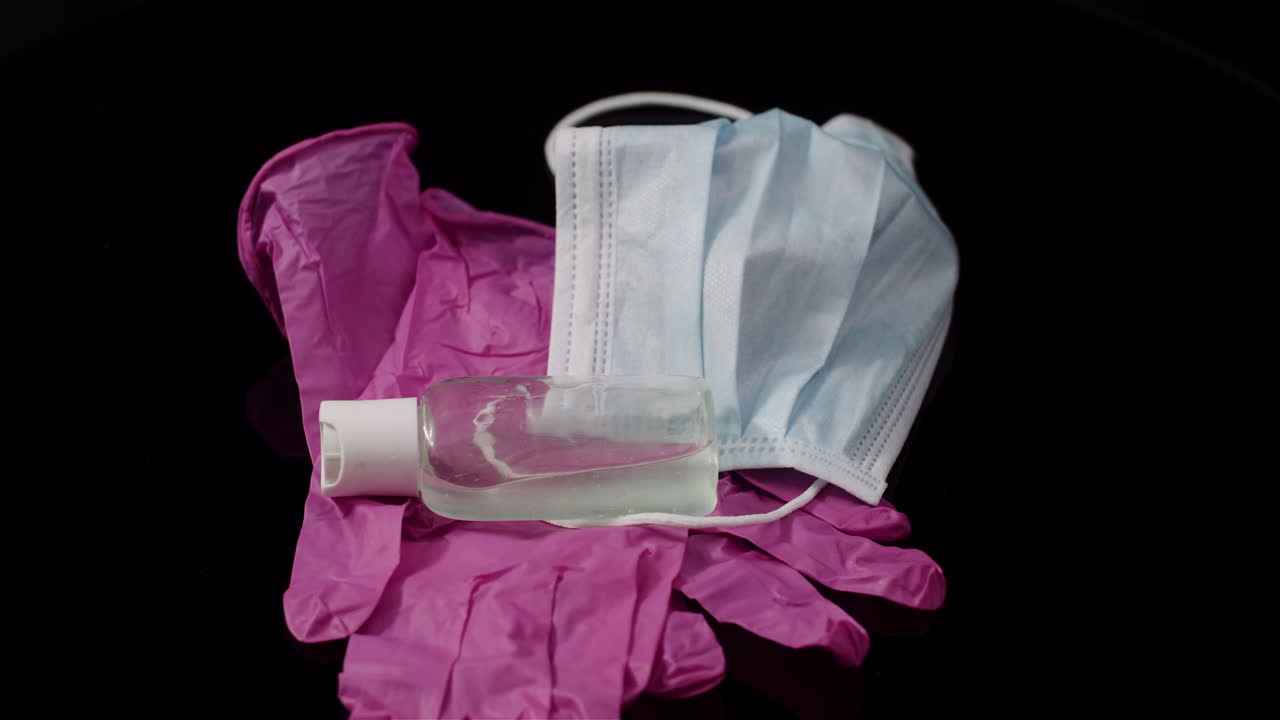 검은 배경 회전 의료 마스크 보호 장갑 1에 고립 된 보라색 보호 마스크