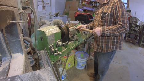 usando un micrómetro para medir una varilla de madera en un torno de madera