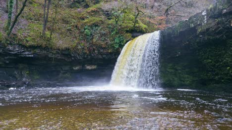 flying over a deep pool to reveal sgwd gwladys waterfall cascading over a rocky ledge