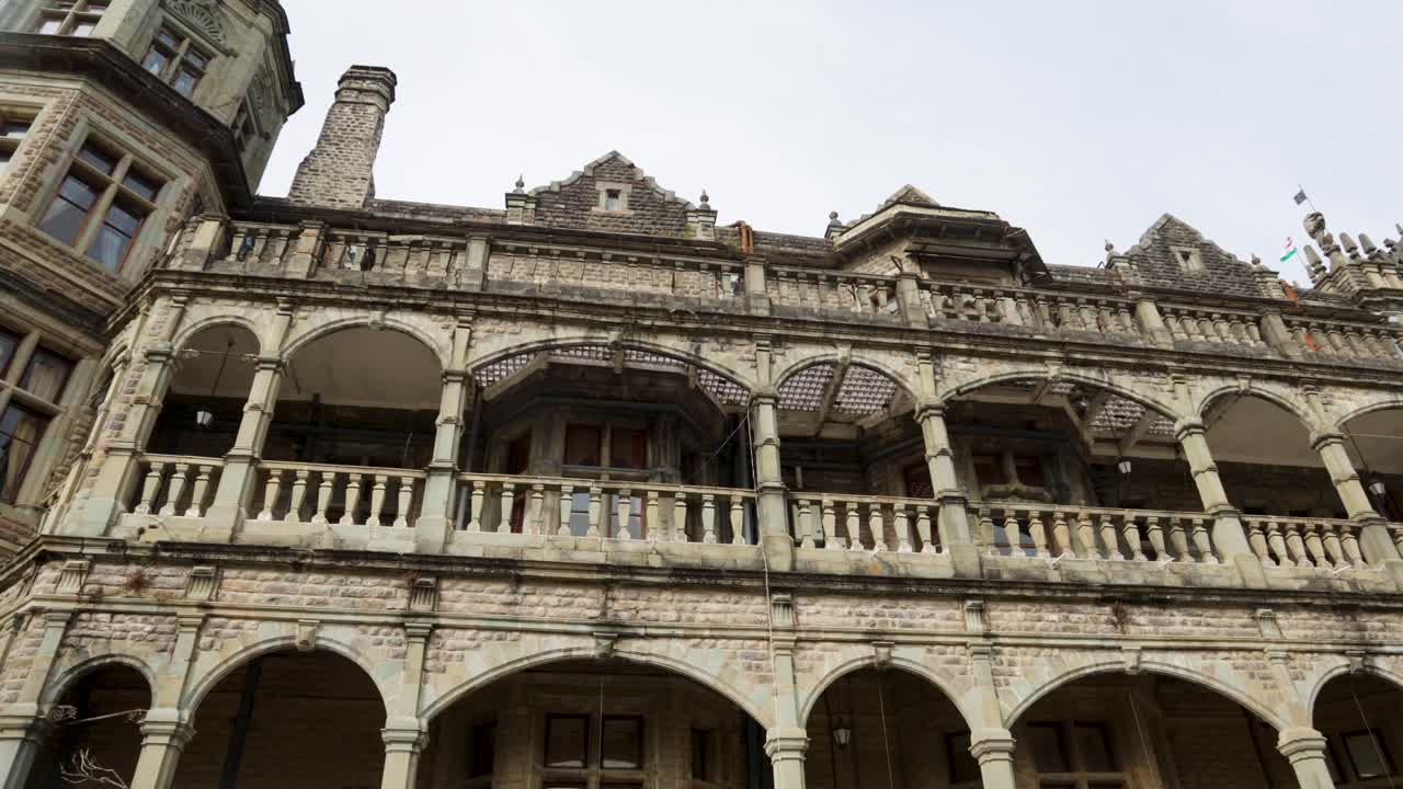 Facciata di un edificio coloniale storico a Shimla con muri in pietra e archi