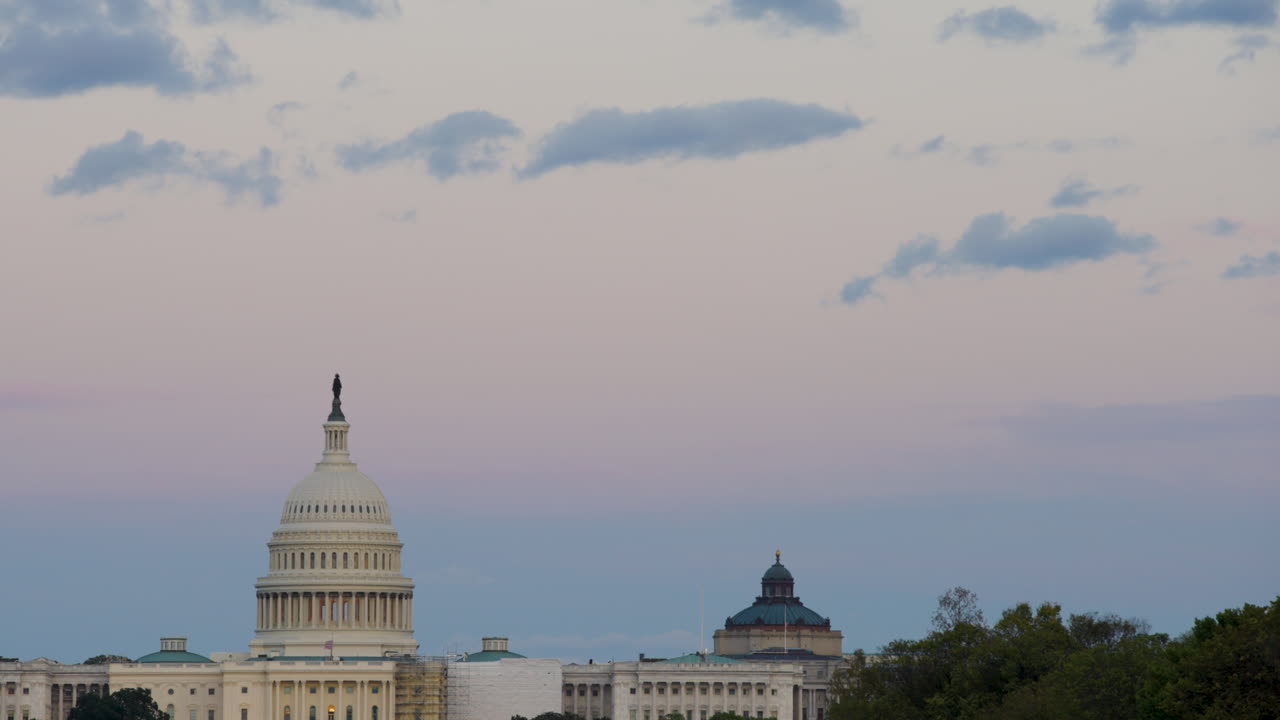 la luz del sol comienza a desvanecerse sobre el edificio del capitolio en washington dc.