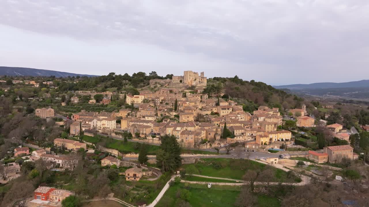 Vista aerea dei tetti medievali e del castello di Lacoste all'alba in Provenza.