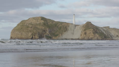 hermoso entorno de la costa de nueva zelanda con formación rocosa y faro en castle point