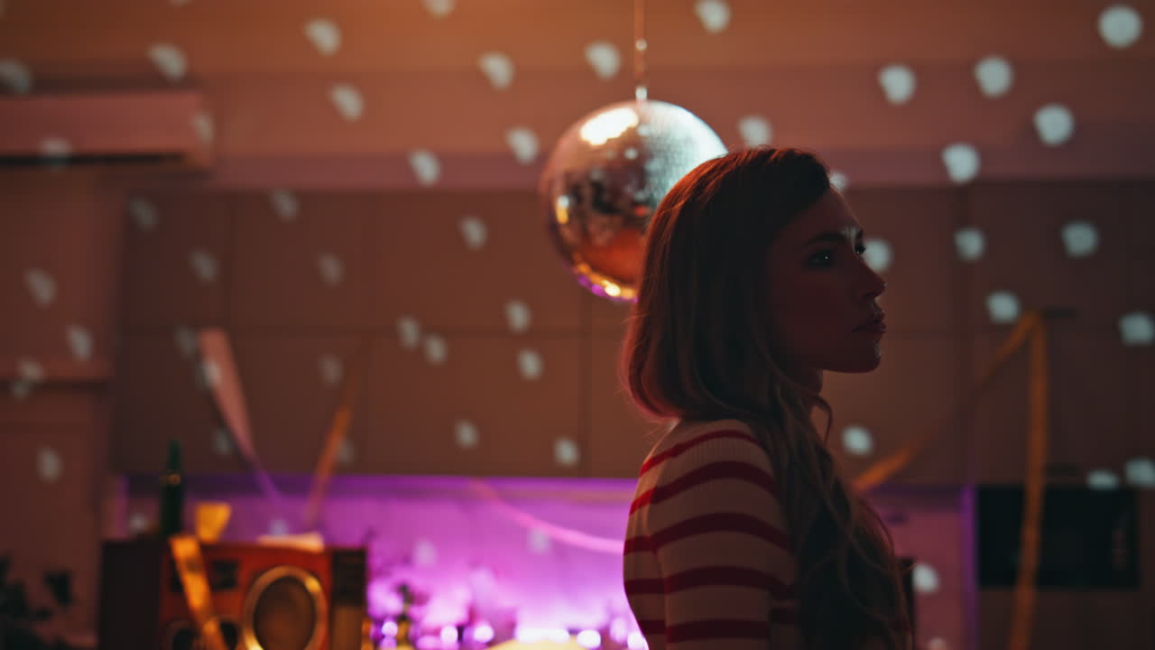 Upset woman standing night apartment with disco ball looking smartphone close up