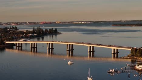 aerial telephoto orbit of captain cook bridge bathed in golden light over the georges river, sydney nsw australia