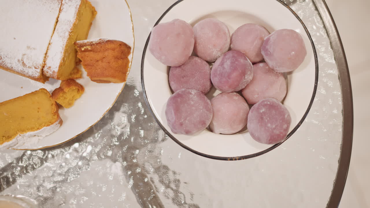 Dessert feast display. Baked goods featuring pink mochi and pumpkin loaf visualized from above. Topdown perspective showcasing selection of delightful desserts including mochi and pumpkin bread