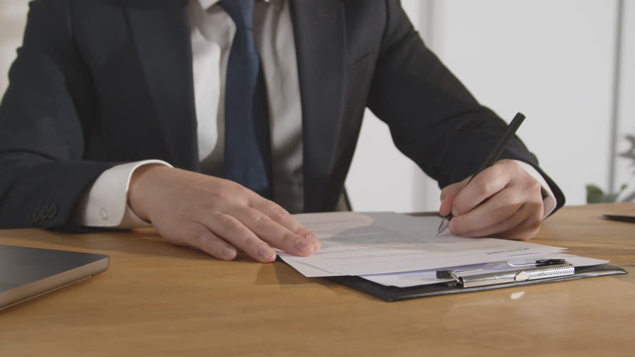 крупный план бизнесмена в офисе, просматривающего и делающего пометки в заявлении или резюме на вакансию