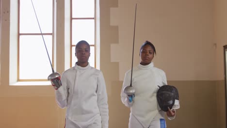 Female-fencer-athletes-during-a-fencing-training-in-a-gym