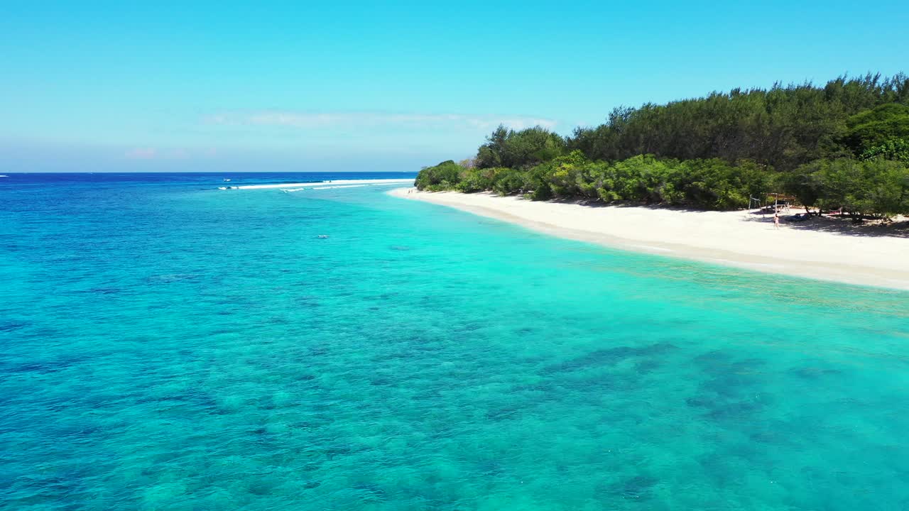 Untouched white sand of exotic beach washed by tranquil clear water of turquoise lagoon under a bright clear blue sky in Caribbean
