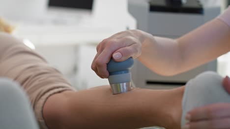 Close-up-of-physical-therapist-using-massaging-machine-on-body.