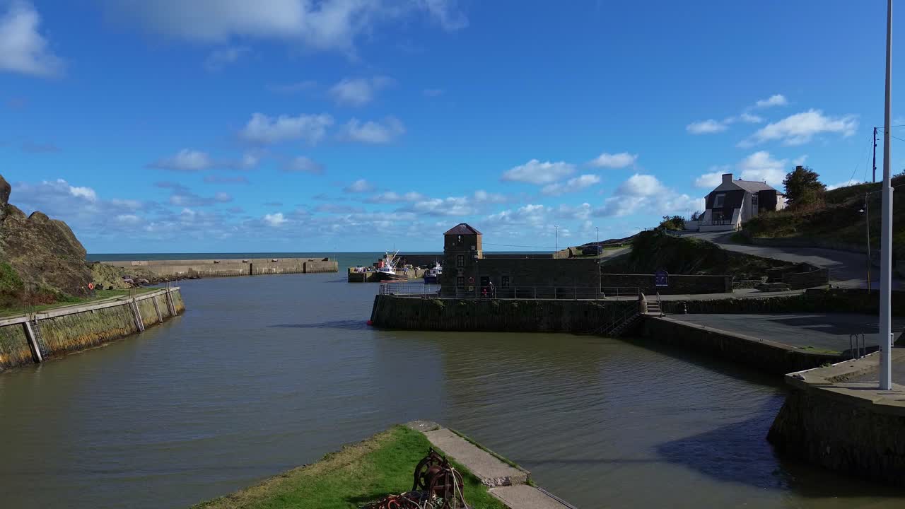 Amlwch harbour aerial view flying towards harbour masters tower house in sunny Welsh marina