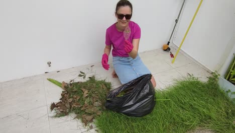 woman cleaning up leaves and grass in the yard