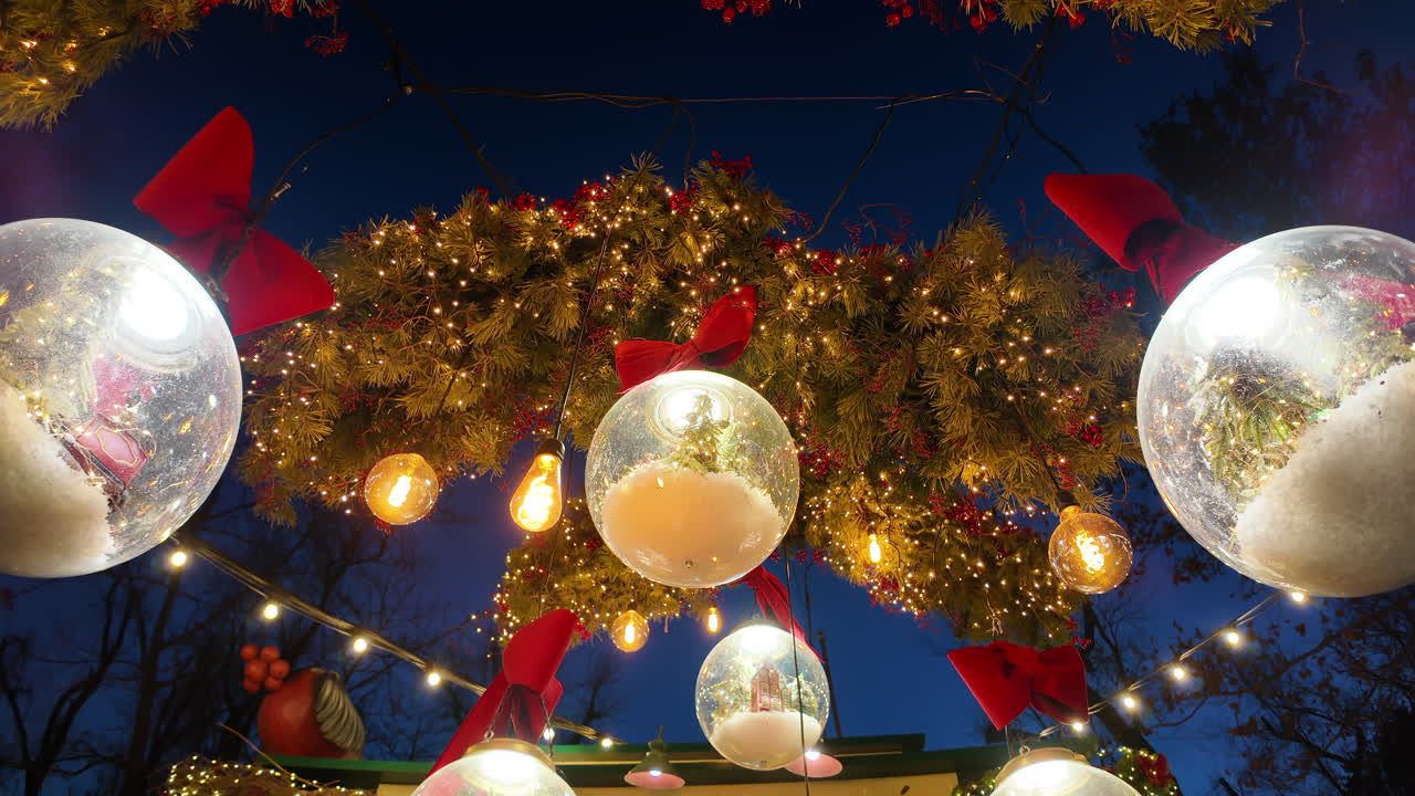 Christmas decorations with transparent bubbles in the evening and green fir tree branches