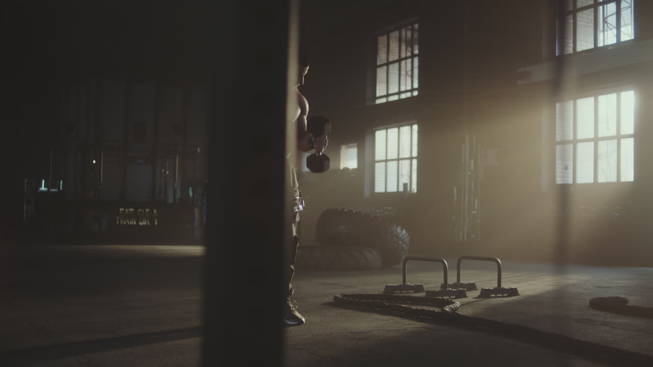 Uomo che si allena con i manubri in palestra