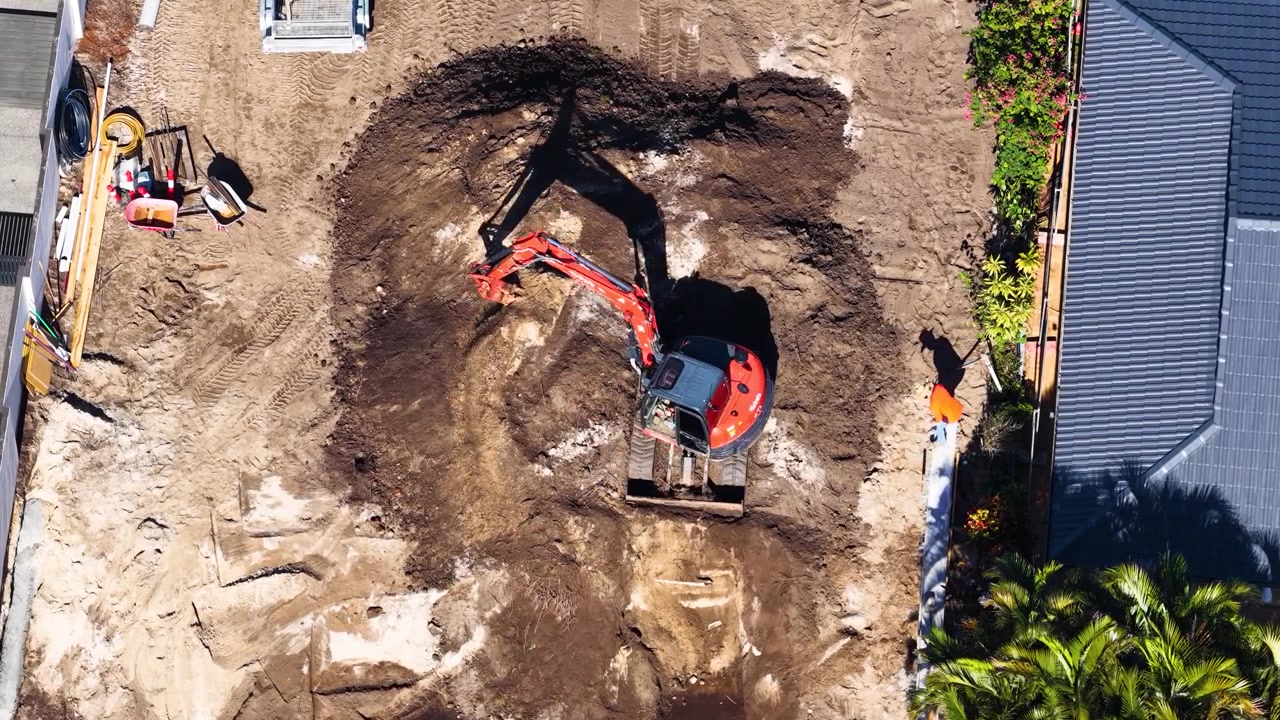 Aerial View of Excavator Digging in Residential Backyard