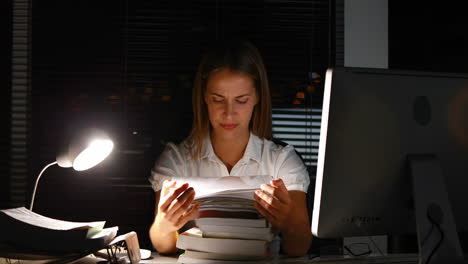 mujer de negocios con documentos por la noche