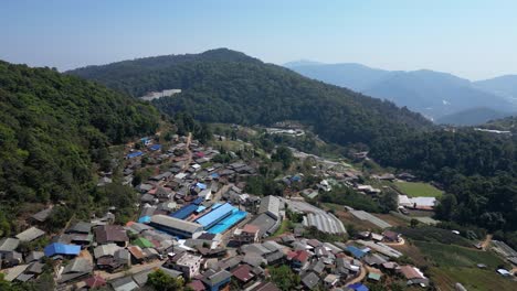 drone flying over rural village in northern thailand, surrounded by nature