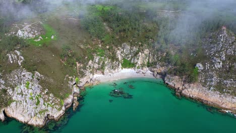 backwards drone movement from the coastal virgin island beach cove with rocky environment and turquoise water, crozon peninsula, brittany, france