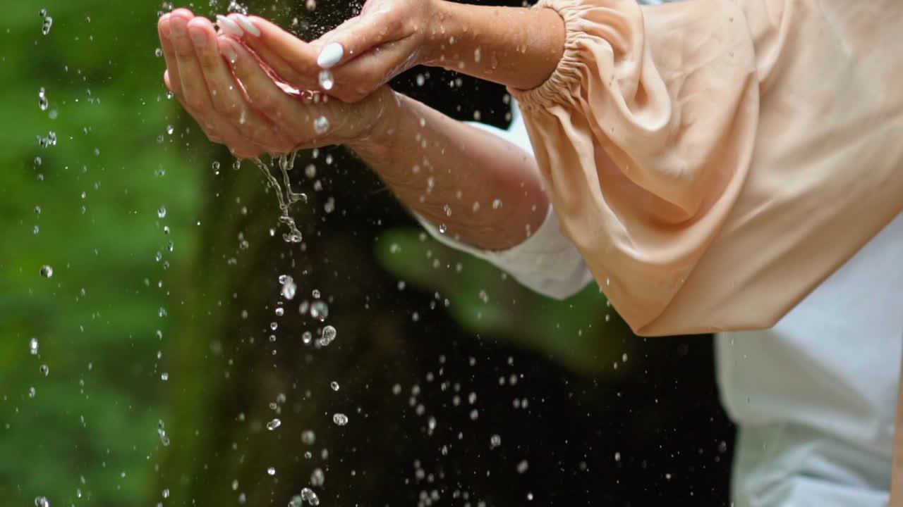 Beautiful couple spending time together. Close up of hands young couple standing and hugging under the rain