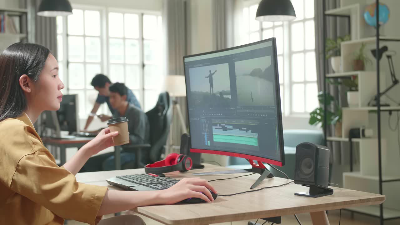 Asian Female Video Editor Works And Drinking Coffee With Her Personal Computer In Office