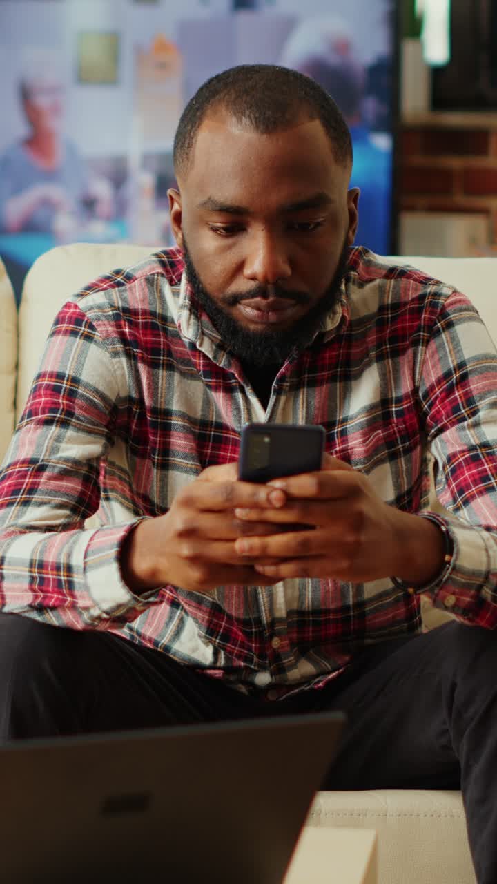 Man using smartphone at home