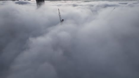 fotografía aérea sobre una nublada y brumosa ciudad de brisbane, con sólo las cumbres de los rascacielos visibles