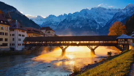 covered wooden bridge over a misty river with alpine mountains at sunrise