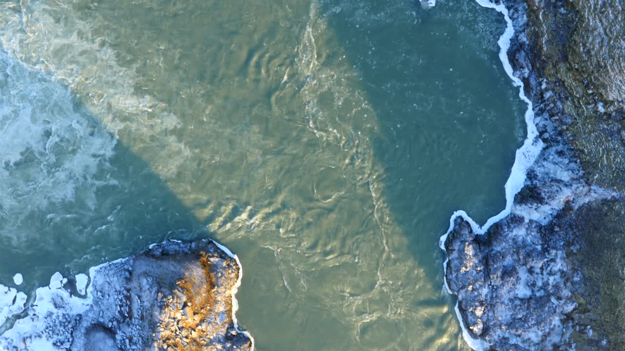 vista aérea de la cascada congelada de urriðafoss en islandia con el río salvaje