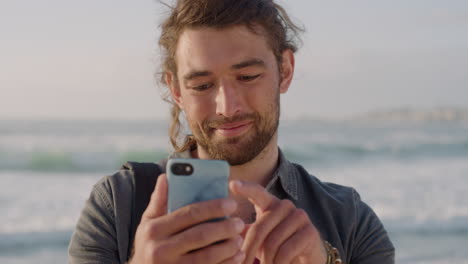 Porträt-Eines-Jungen-Mannes,-Der-Sein-Smartphone-Nutzt,-Um-SMS-Zu-Schreiben-Und-Online-Zu-Surfen,-Urlaubserlebnisse-In-Sozialen-Medien-Zu-Teilen-Und-Mobile-Kommunikation-Vor-Sonnigem-Strandhintergrund-Zu-Genießen