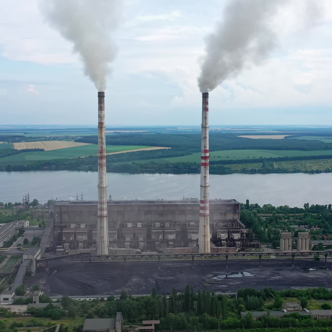Huge factory producing electricity. Aerial Shot of polluting coal fired power reactors