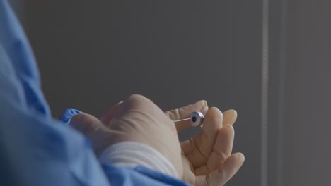 vista lateral de un trabajador de la salud insertando una jeringa en un vial de la nueva vacuna covid-19