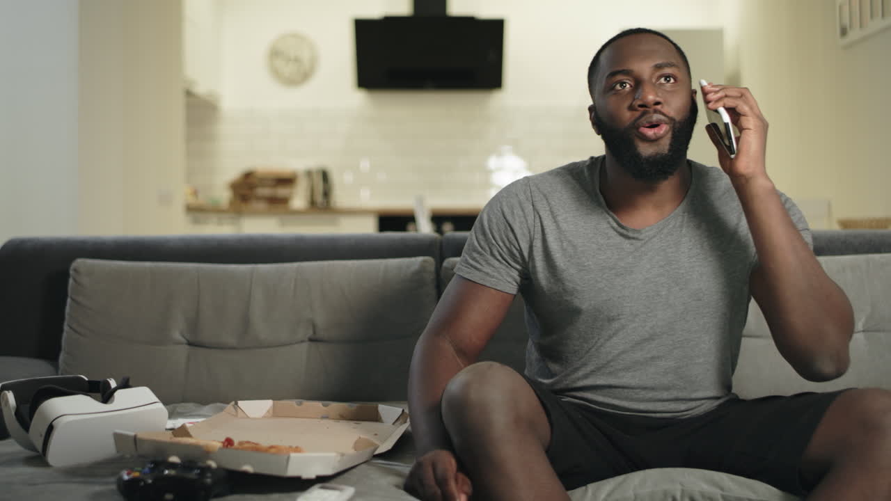 homem bonito a ver um jogo de futebol no sofá.