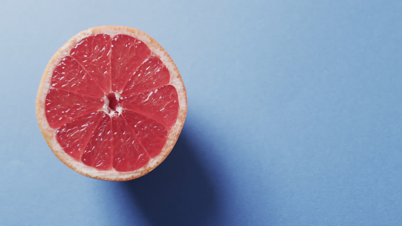 Video di pompelmo rosso affettato con spazio per il testo su sfondo blu