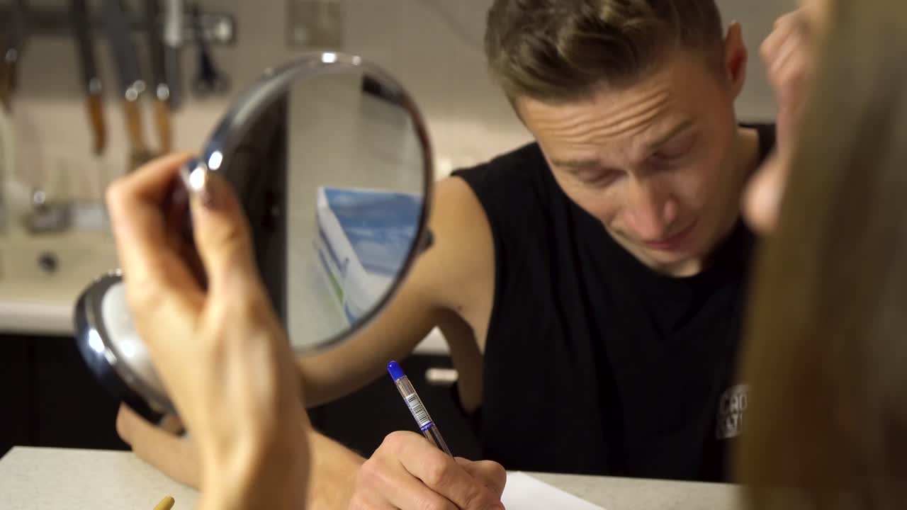 persona escribiendo y mirando el reflejo en la cocina