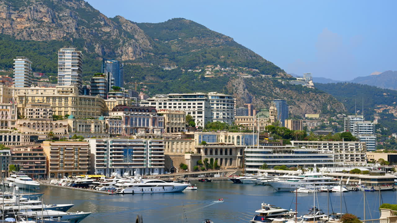 View of boats docked in the Monaco Marina with the skyline of the city on the background