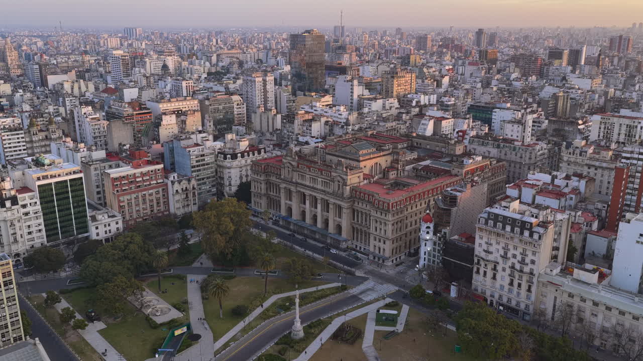 Aerial drone footage rising above Buenos Aires revealing dense urban skyline, city blocks and architecture in Argentina during daylight