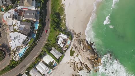 Eine-Vogelperspektive-Zeigt-Autos,-Die-Am-Strand-Von-Camps-Bay-In-Kapstadt-Südafrika-Vorbeifahren-1