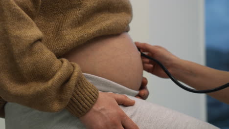 doctor checking pregnant woman's belly