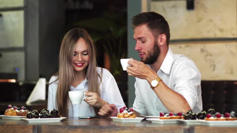 Pareja-Feliz-Compartiendo-Contenido-Multimedia-En-Línea,-Todos-Con-Su-Teléfono-Inteligente-En-Una-Cafetería