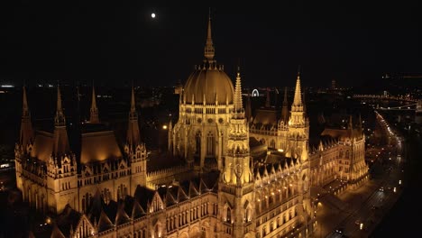 drone orbits above hungarian parliament building at night in budapest, hungary